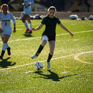 Female soccer player about to kick ball